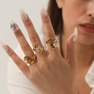 Detailed view of irregular gold twisted rings with large zircon stones on hand