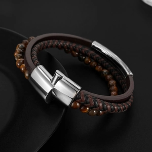 Detail view of multi-layer tiger eye stone beads and braided brown leather bracelet with silver clasp