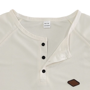 Close-up of waffle texture fabric and black buttons on the cream white Henley shirt
