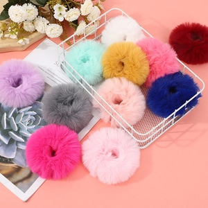 Lot de chouchous en peluche fausse fourrure de lapin dans un panier sur fond rose