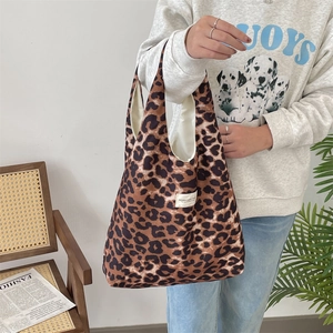 Detail of leopard print canvas tote bag with a white woven label on the front surface