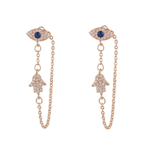 Detailed close-up of rose gold Evil Eye and Hamsa Hand chain earrings with blue crystals