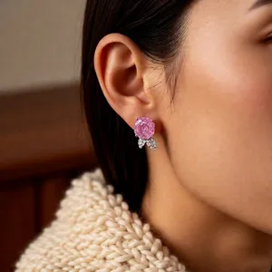 Silver needle zircon rose stud earrings with pink petals and leaf accents on model