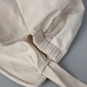 Detail of beige sun hat featuring elastic back slit and neat stitching for ponytails