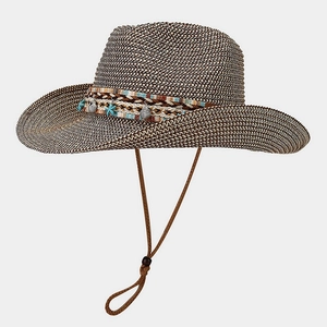 Detail of woven straw cowboy hat with turquoise starfish beads and shell decorations