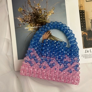 Detail of blue and pink handmade beaded handbag featuring colorful gradient woven patterns