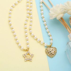 Detail of star and heart pendants with Mama engraving on pearl and gold necklaces