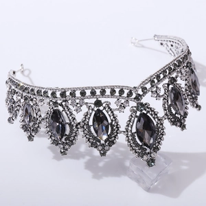 Macro detail of vintage baroque crown featuring dark grey crystal gems and silver rhinestones