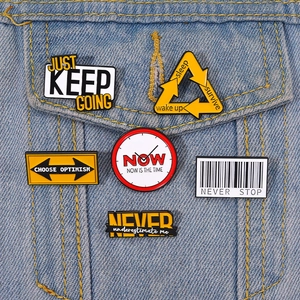 Gros plan de six badges en émail créatifs avec texte inspirant sur une poche de veste