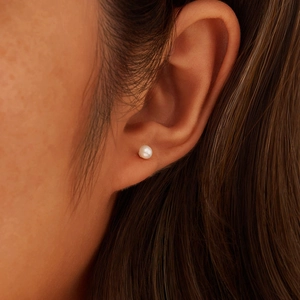 Close-up of a S925 sterling silver stud earring with a round white freshwater pearl