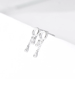Detail of silver drop earrings with water-drop crystals and long fringe chain tassels