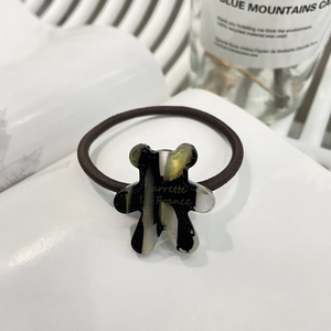 Cute teddy bear charm hair tie with black and gold marble pattern on white book