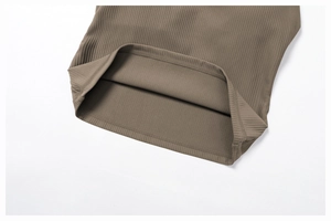 Macro detail of ribbed knit fabric hem with fine double-needle stitching in brownish grey