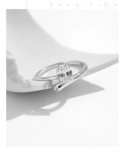 Macro detail of silver geometric ring with oval zircon on a white stone background
