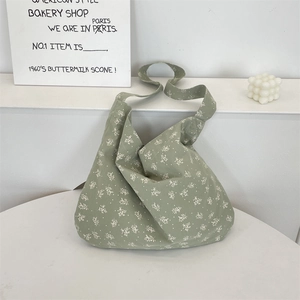 Detailed texture of green floral canvas tote bag featuring white small flower patterns
