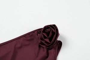 Detailaufnahme des weinroten asymmetrischen Tops mit 3D Stoffrose und Schulterstruktur