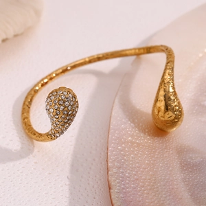 Detail of 18K gold-plated teardrop bangle featuring micro-pave crystals and polished finish