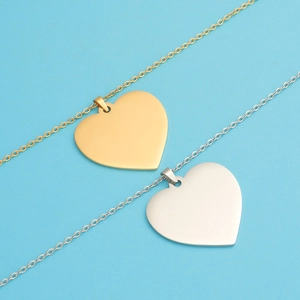 Flat lay of gold and silver heart-shaped mirror polished stainless steel pendants
