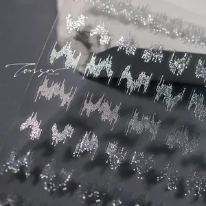 Macro shot of silver embossed 3D nail art decals with metallic texture and reflective finish