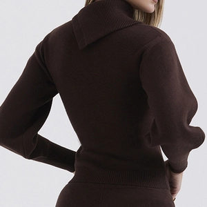 Detailed back view of a dark brown knit turtleneck sweater with ribbed cuffs and hem