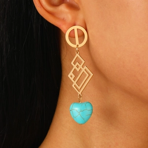 Detailed view of bohemian gold hollow earrings with a blue heart-shaped turquoise pendant