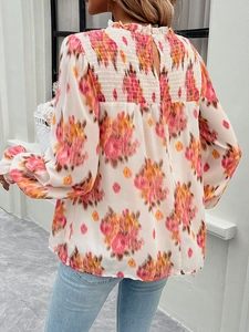 Detail view of floral chiffon blouse featuring ruffle stand collar and back pleat design
