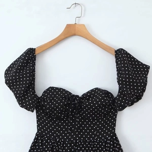 Polka dot summer dress with puff sleeves and sweetheart neckline on wooden hanger