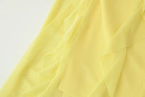Detailed macro view of yellow mesh fabric texture and layered semi-transparent structure