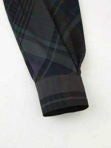 Détail du poignet de la manche de cette chemise à carreaux sombres et texture premium