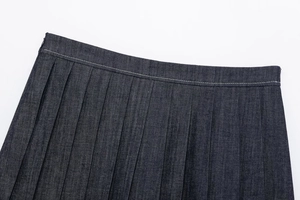 Detail of dark blue denim pleated skort with white contrast stitching and waist pleats