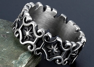 Macro shot of vintage silver punk ring with sun totem and filigree on green stone