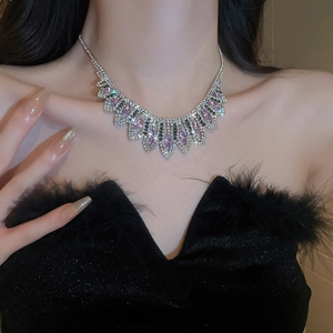 Detail view of v-shaped tassel necklace with sparkling pink and clear crystals on a model