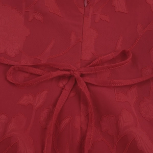 Close-up of red jacquard dress featuring back zipper detail and floral texture