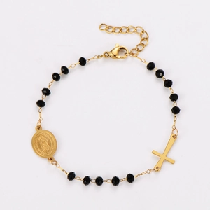 Detail of beaded religious bracelet with golden cross and Saint Mary medal charm