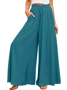 Detail of teal wide-leg trousers featuring elastic drawstring waist and pocket texture