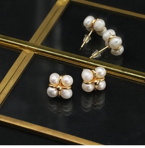 Detail of natural freshwater pearl earrings with four-pearl cluster in golden setting
