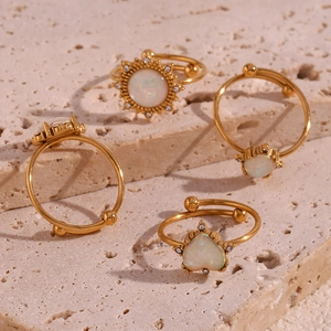 Close-up of 18K gold-plated adjustable rings featuring iridescent white opal heart designs