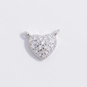 Macro detail of silver heart charm with cubic zirconia inlay for jewelry making