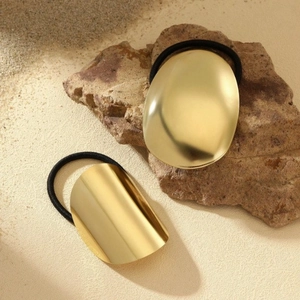 Two gold metal hair ties with high elasticity shown on natural stone background