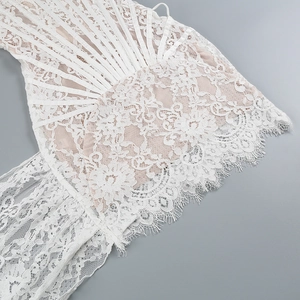 Intricate white lace embroidery detail with elegant fringe hem and corset boning structure