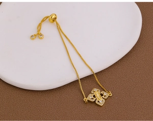 Detail of gold adjustable box chain bracelet with Virgin Mary and zircon pavé charm