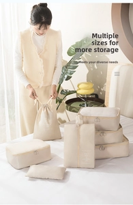 Detail view of cream-colored waterproof travel organizers used for sorting clothes on bed