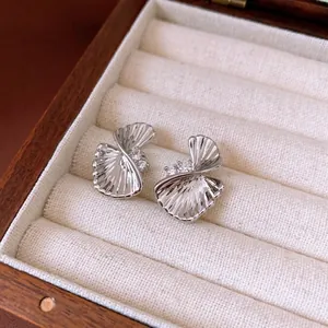 Elegant twisted silver fan-shaped earrings with sparkling crystals in a jewelry box