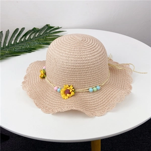 Close-up of beige woven straw hat featuring sunflower accents and colorful bead details