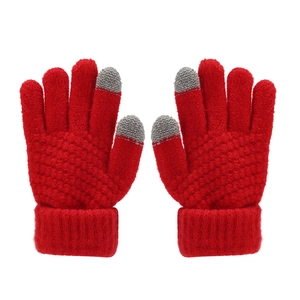 Detail view of red knitted winter gloves with grey touchscreen-compatible fingertips
