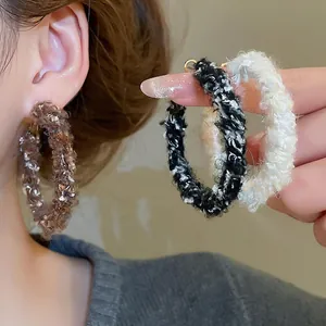 Boucles d'oreilles circulaires en tricot avec texture de fil en tons marron et blanc