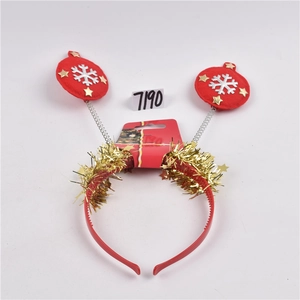 Christmas headband with red spring balls and gold tinsel stars on a white background