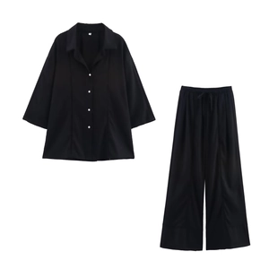 Detailed flat lay of black V-neck linen shirt and wide-leg pants set with size S label