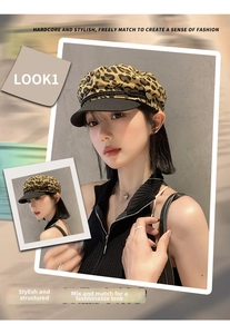 Close-up of leopard print newsboy cap with black brim and gold button detail