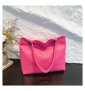 Detail of fuchsia woven tote bag with Intrecciato texture and large capacity style